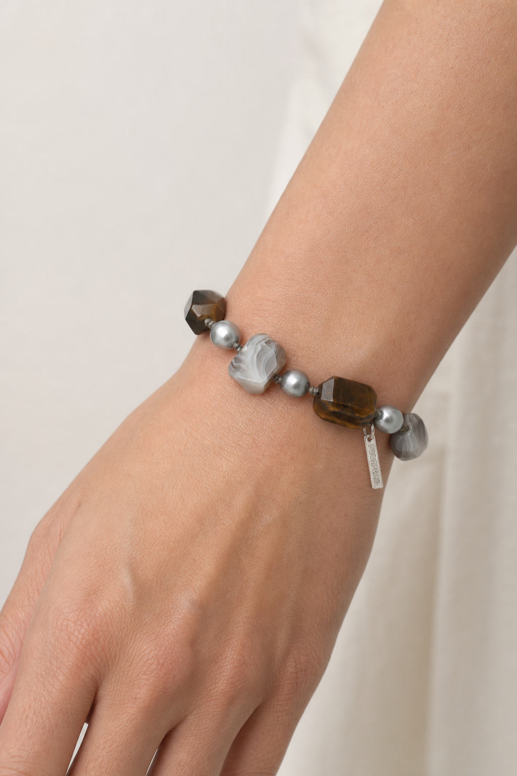Agate tiger's eye and baroque pearl bracelet worn on wrist