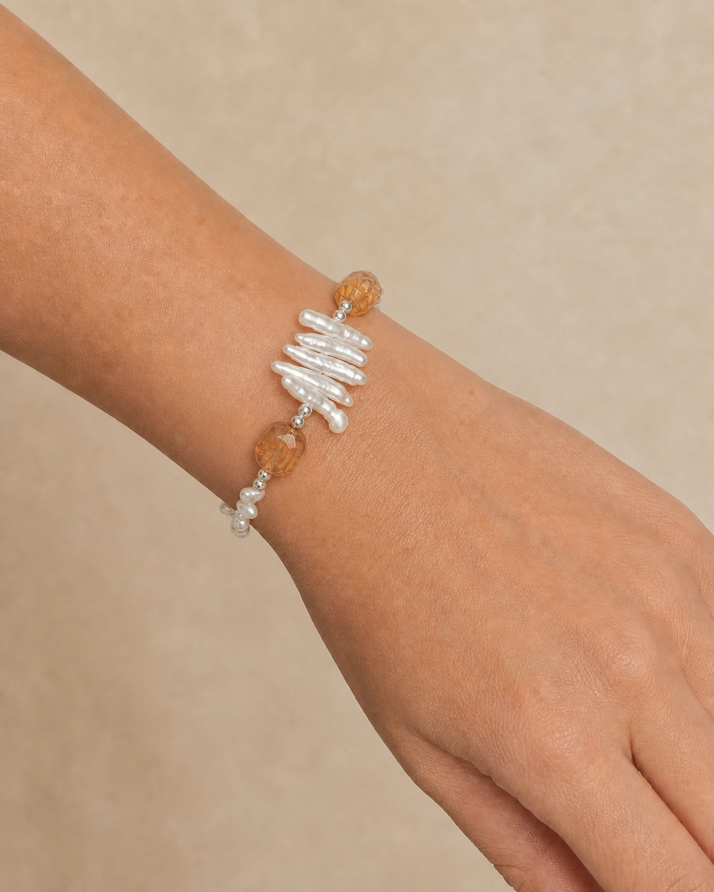 Citrine and baroque pearl bracelet securely fastened on wrist at realistic scale