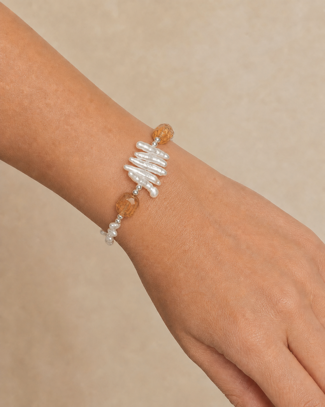 Citrine and baroque pearl bracelet securely fastened on wrist at realistic scale
