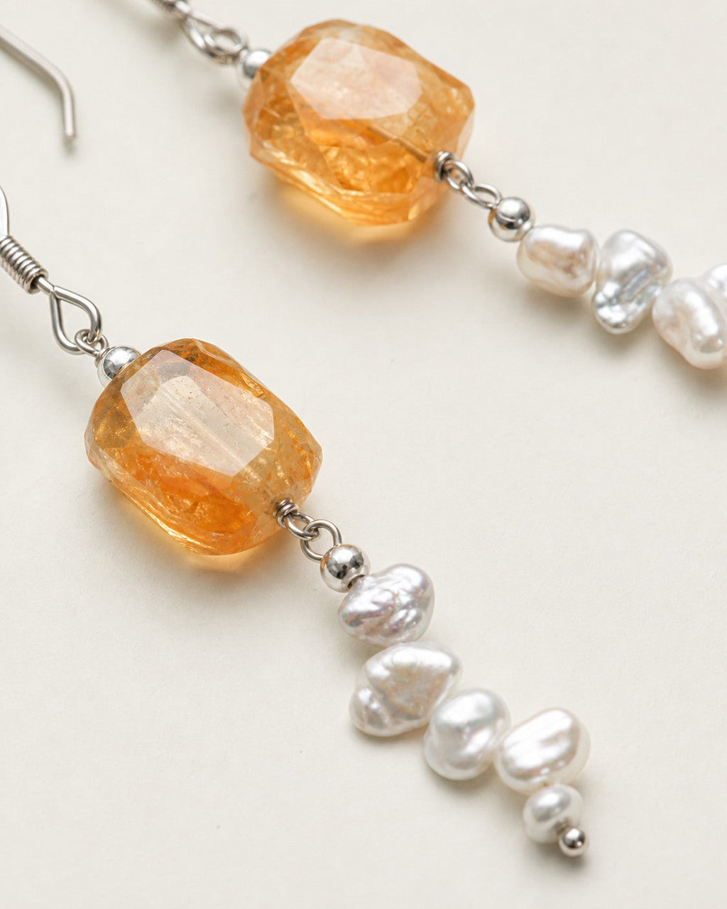 Close-up of citrine, baroque freshwater pearls and sterling silver earring connections