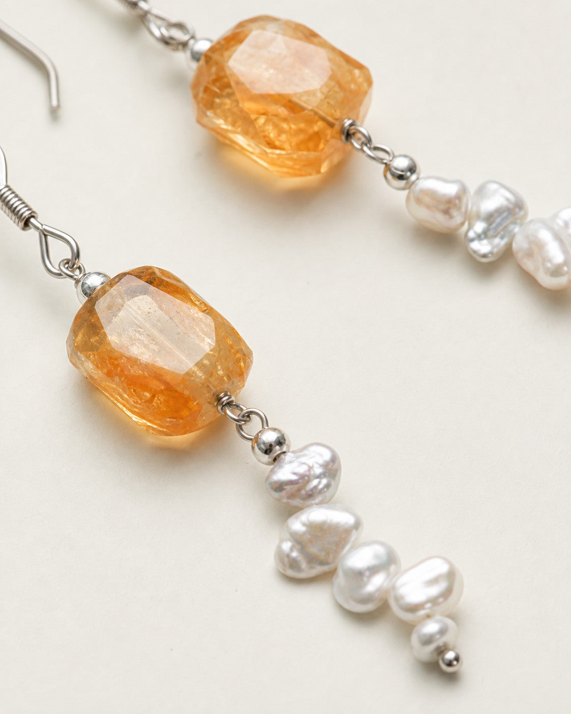 Close-up of citrine, baroque freshwater pearls and sterling silver earring connections