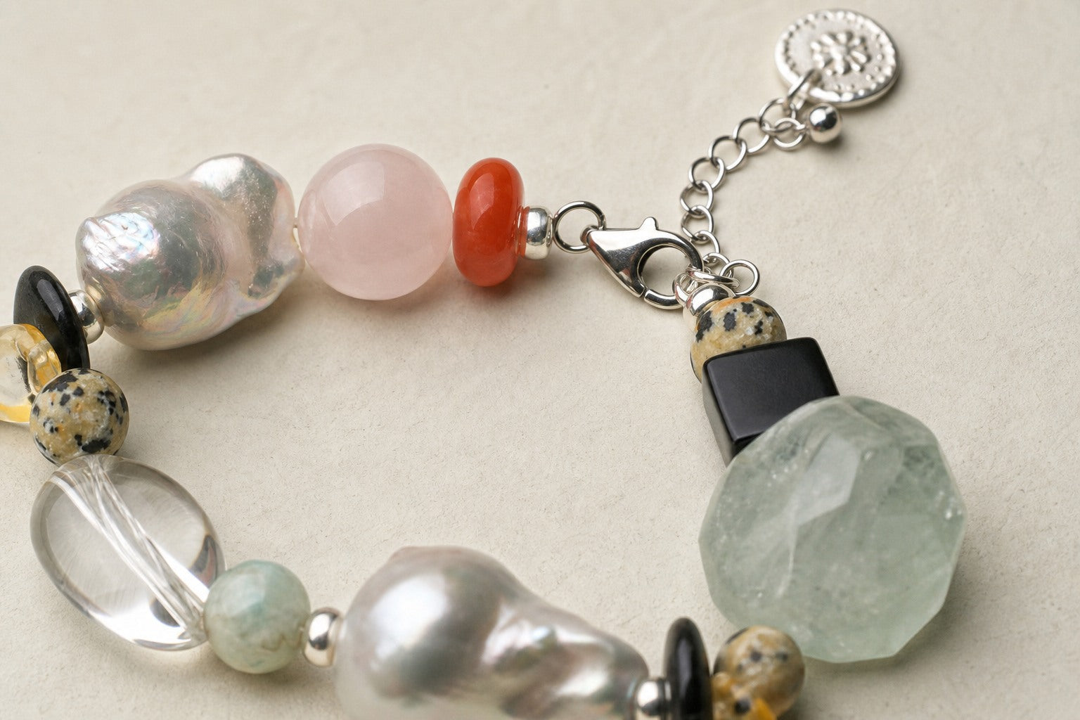 Close-up of clear quartz, green quartz, pearls and sterling silver bracelet clasp workmanship