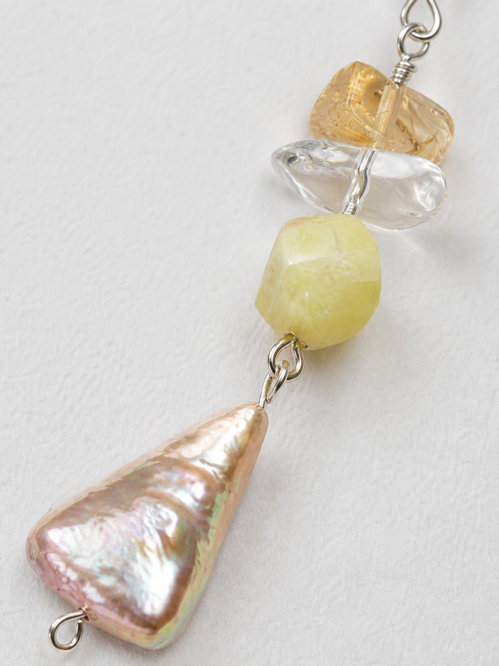 Close-up of citrine, clear quartz, freshwater pearl and sterling silver earring workmanship