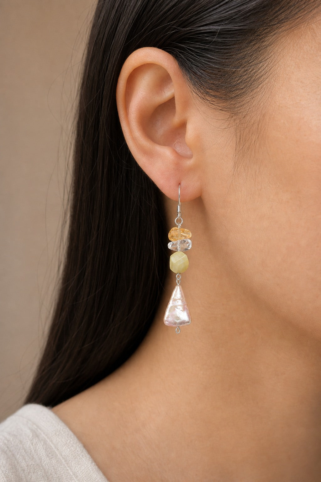 Citrine, clear quartz and freshwater pearl earrings worn on an ear at realistic scale