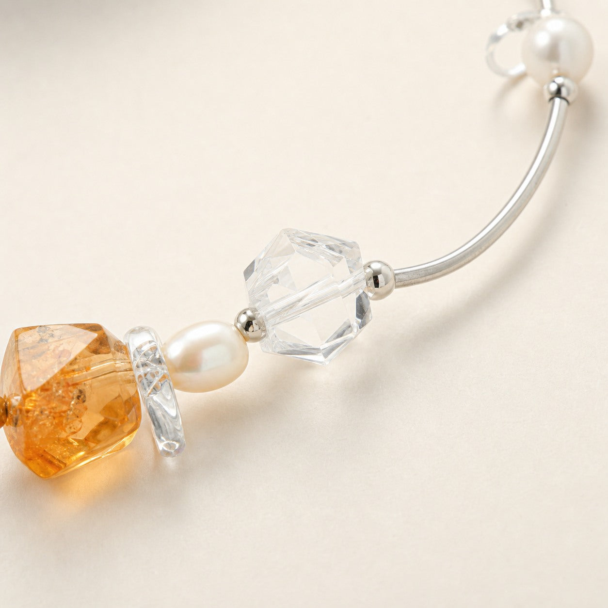 Close-up of citrine, clear quartz, pearls and sterling silver necklace workmanship