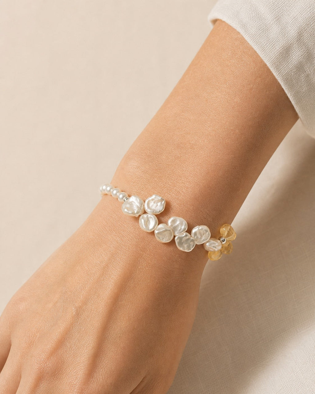 Citrine and freshwater pearl bracelet worn securely around the wrist at realistic scale