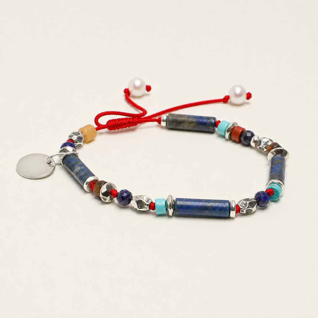 Citrine and lapis lazuli bracelet shown from a low alternate angle with red cord adjustment