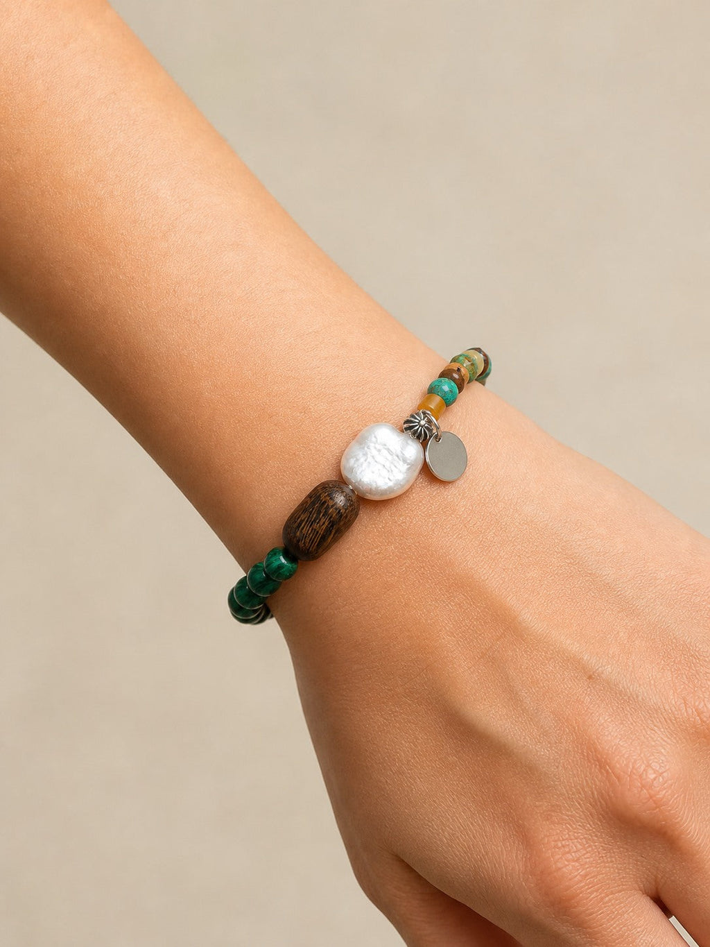 Citrine, malachite, turquoise, wood and baroque pearl bracelet worn around the wrist