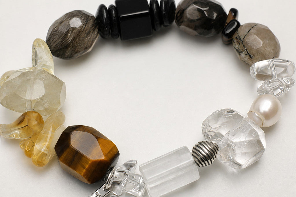 Close-up of citrine, smoky quartz, clear quartz, pearl and sterling silver bracelet workmanship