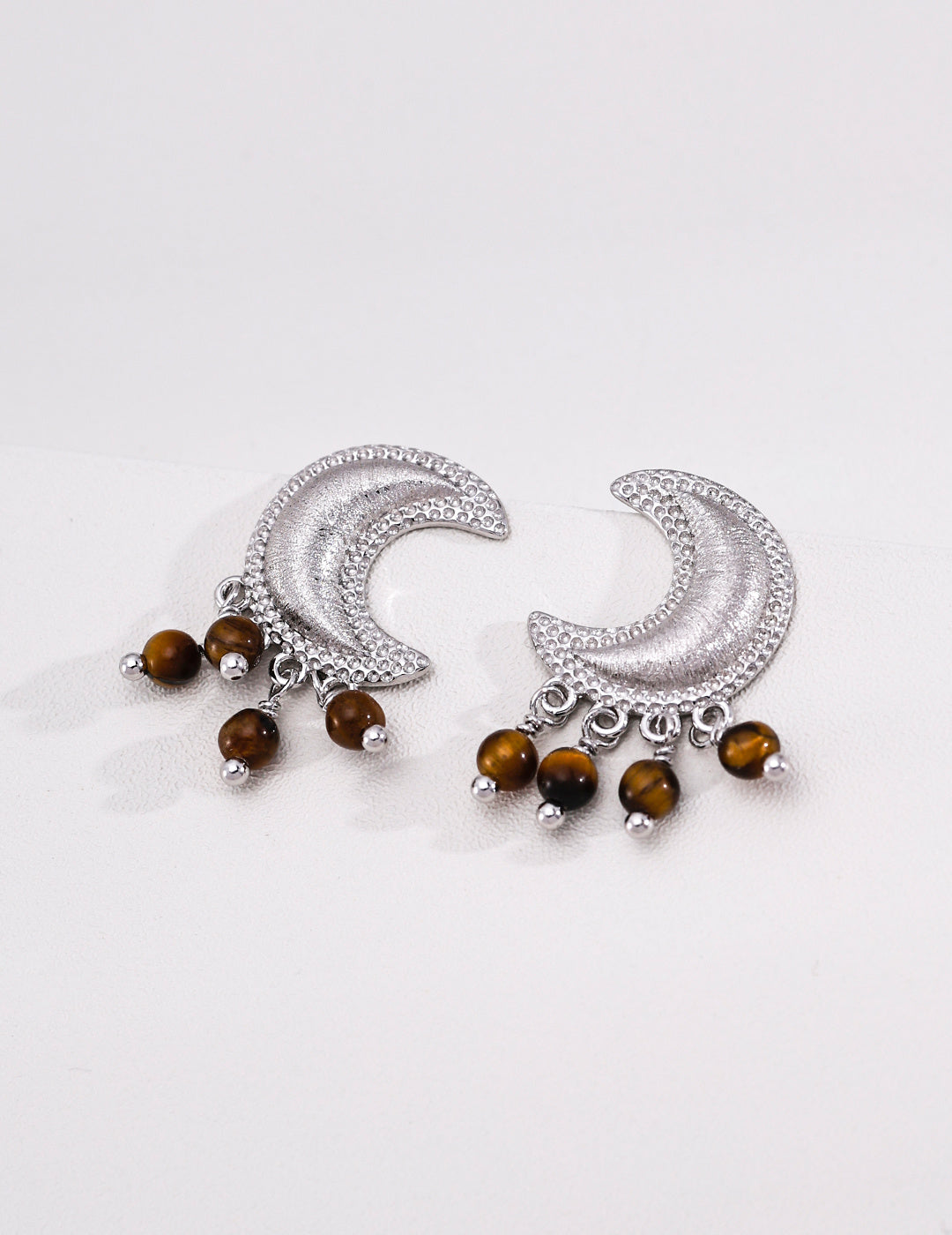 Silver-tone crescent moon earrings with tiger's eye drops