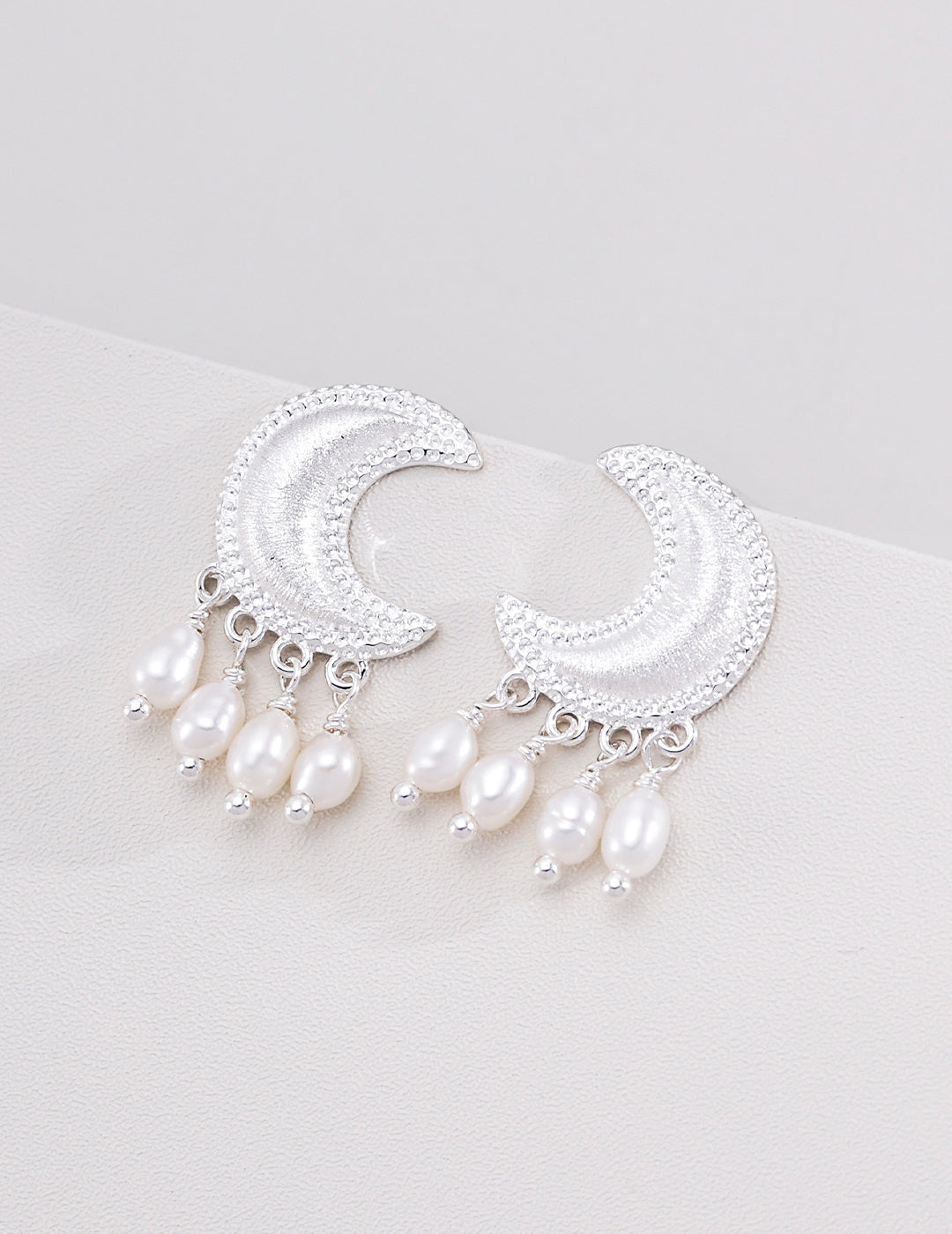 Silver-tone crescent moon earrings with small pearl drops