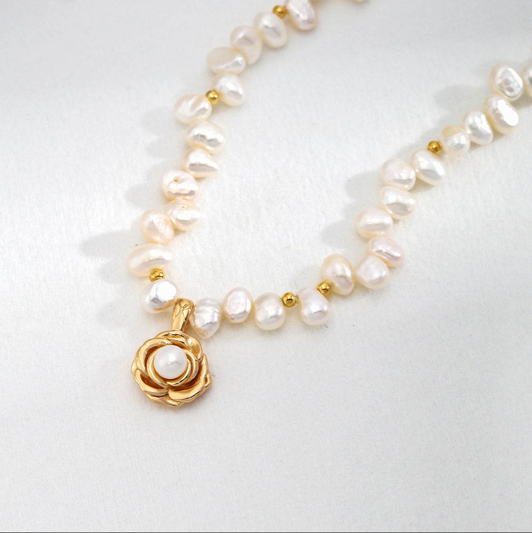 Close-up of the gold-tone camellia pendant and pearl strand