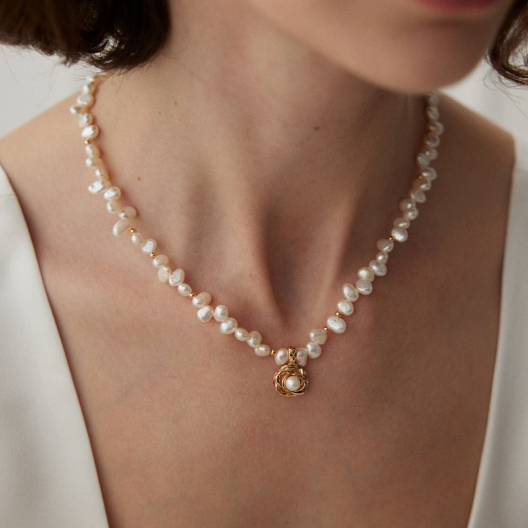 Close-up of the camellia pearl necklace worn at the neckline