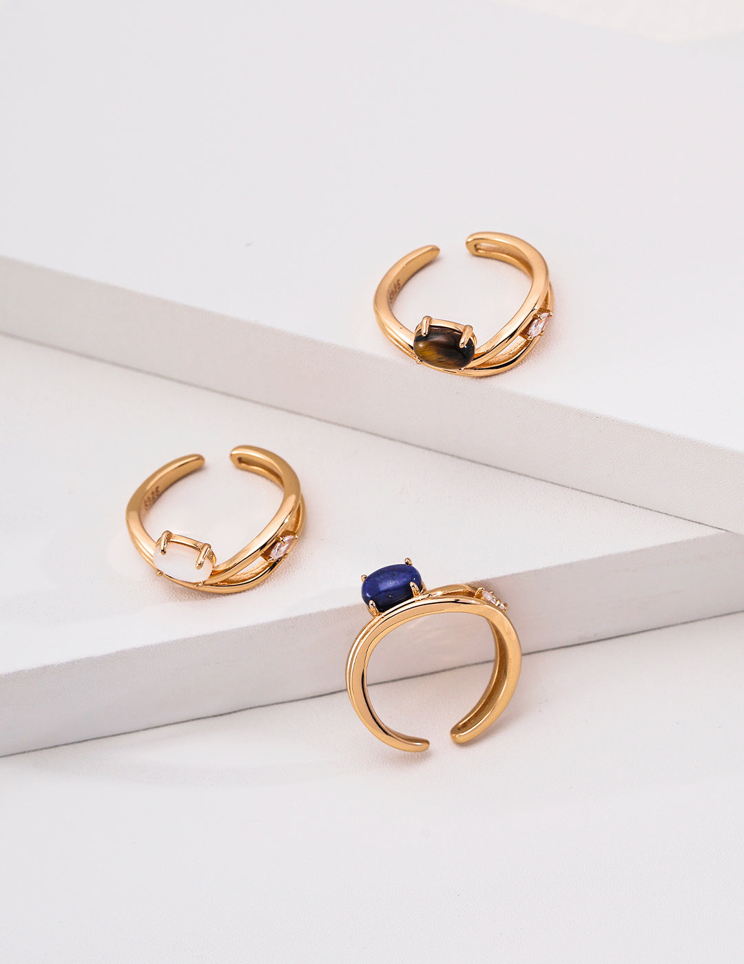 Side views of oval gemstone crossover rings