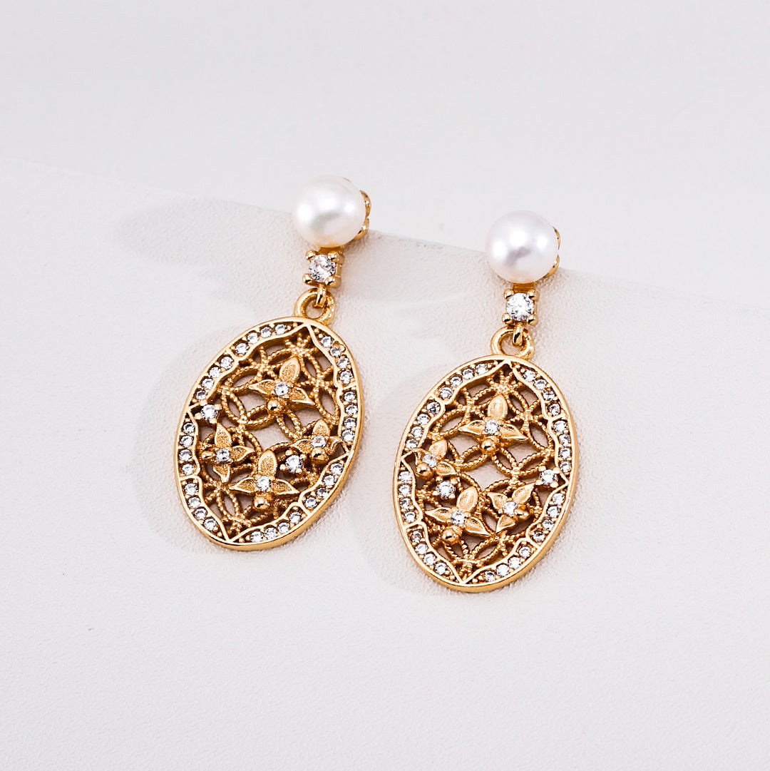 Close-up of vintage gold-tone pearl filigree drop earrings