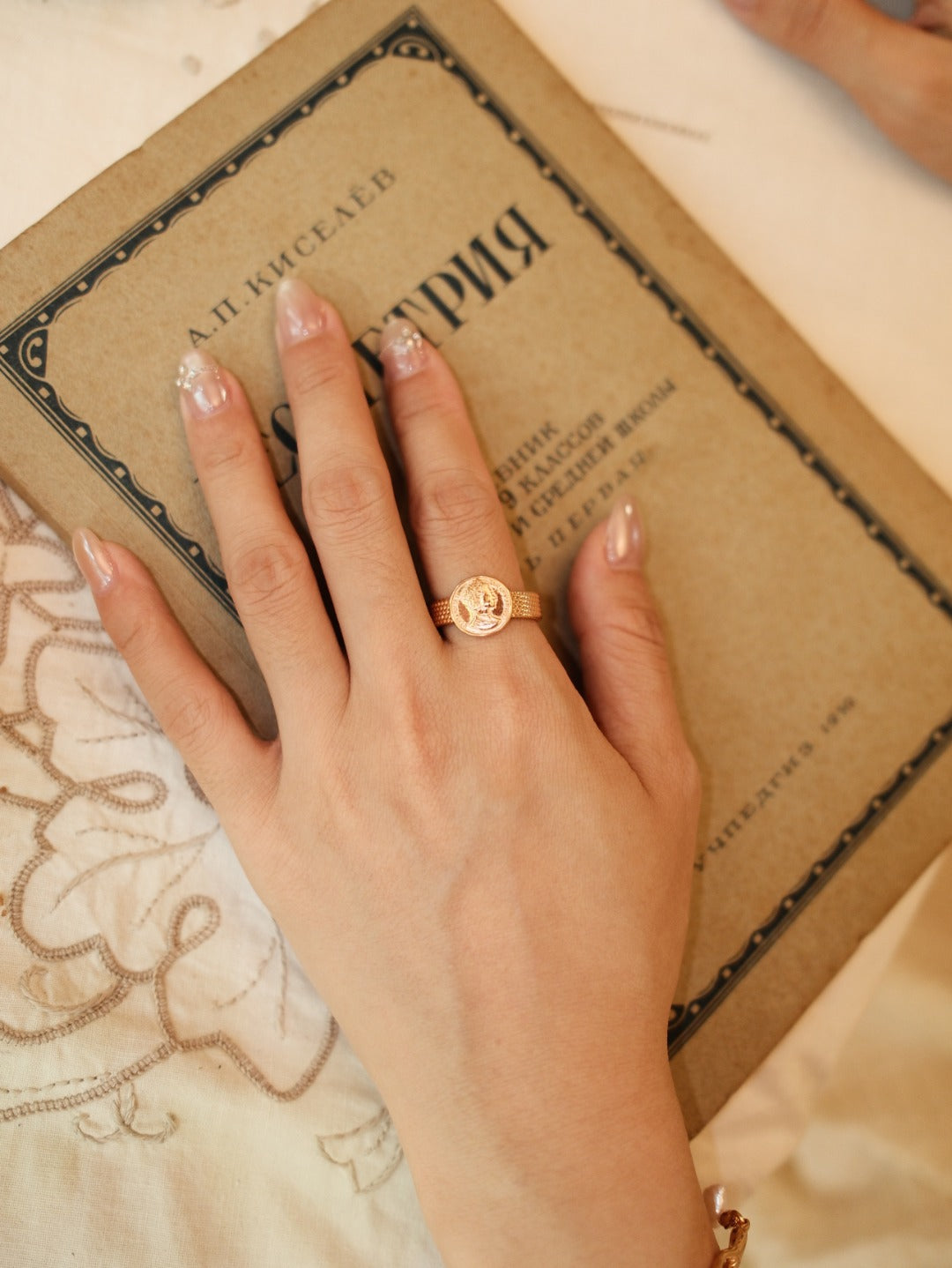 Portrait medallion ring shown on a hand with other jewellery