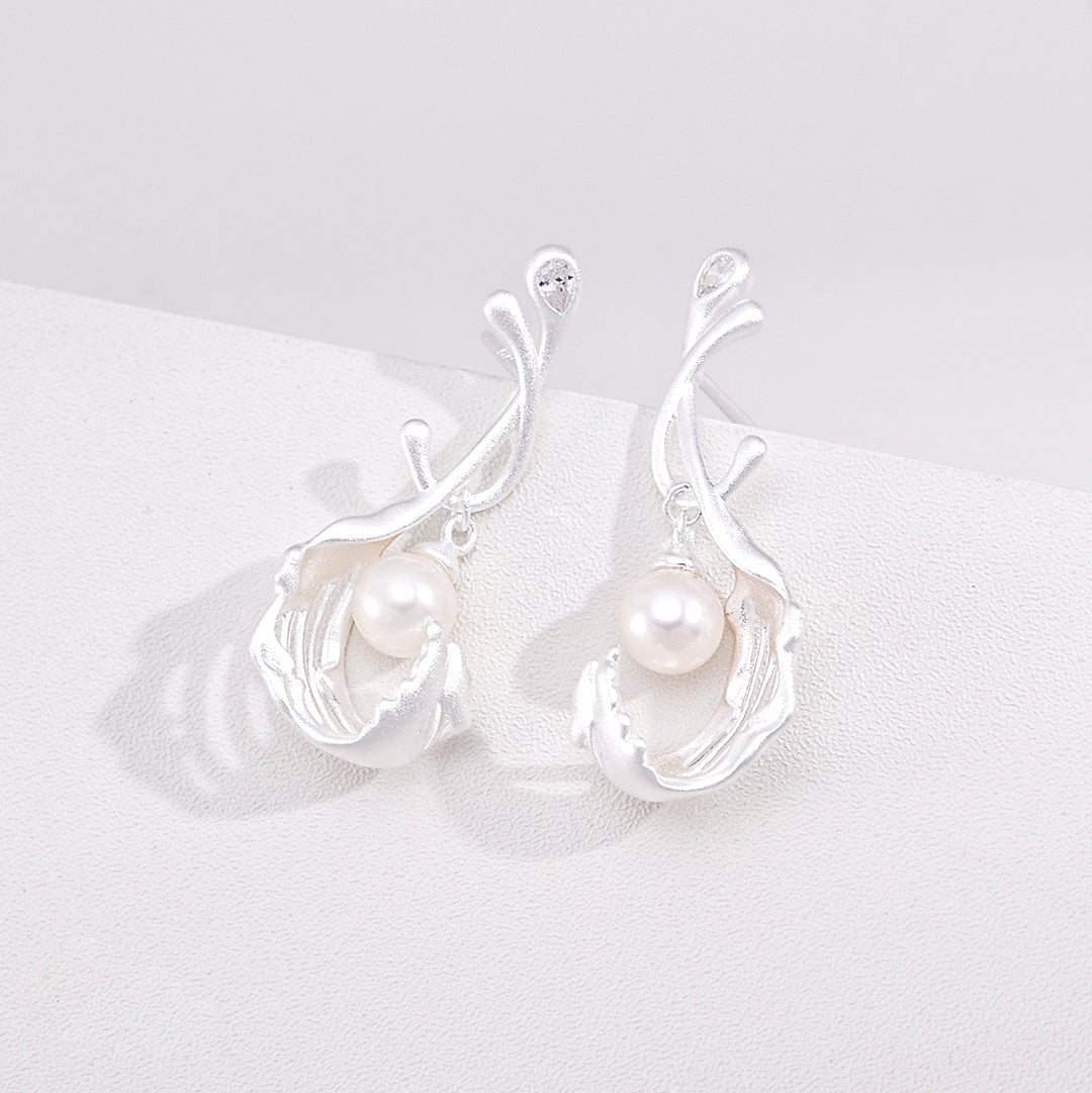 Silver-tone pearl drop earrings with curved stems and sculptural drops