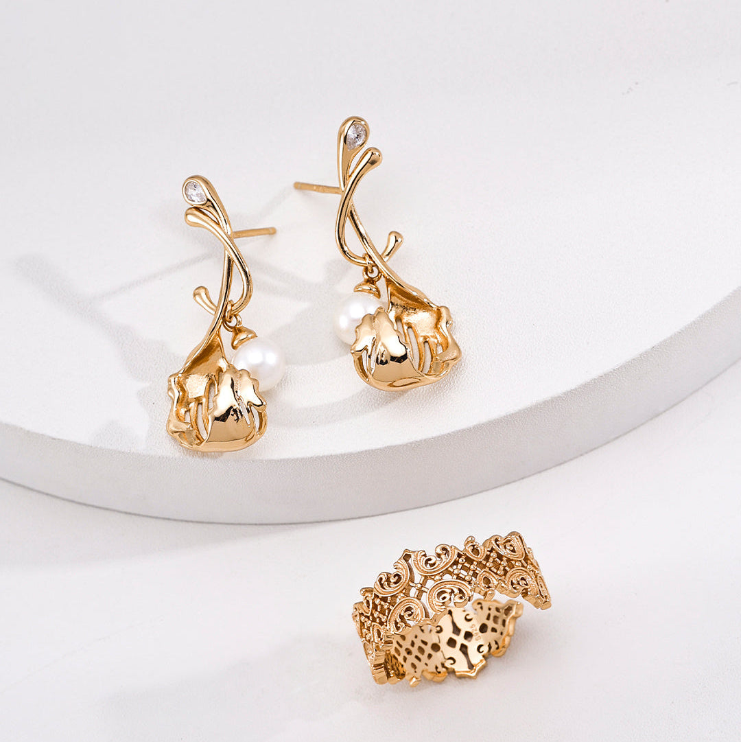 Vintage gold-tone pearl drop earrings styled beside a separate textured ring