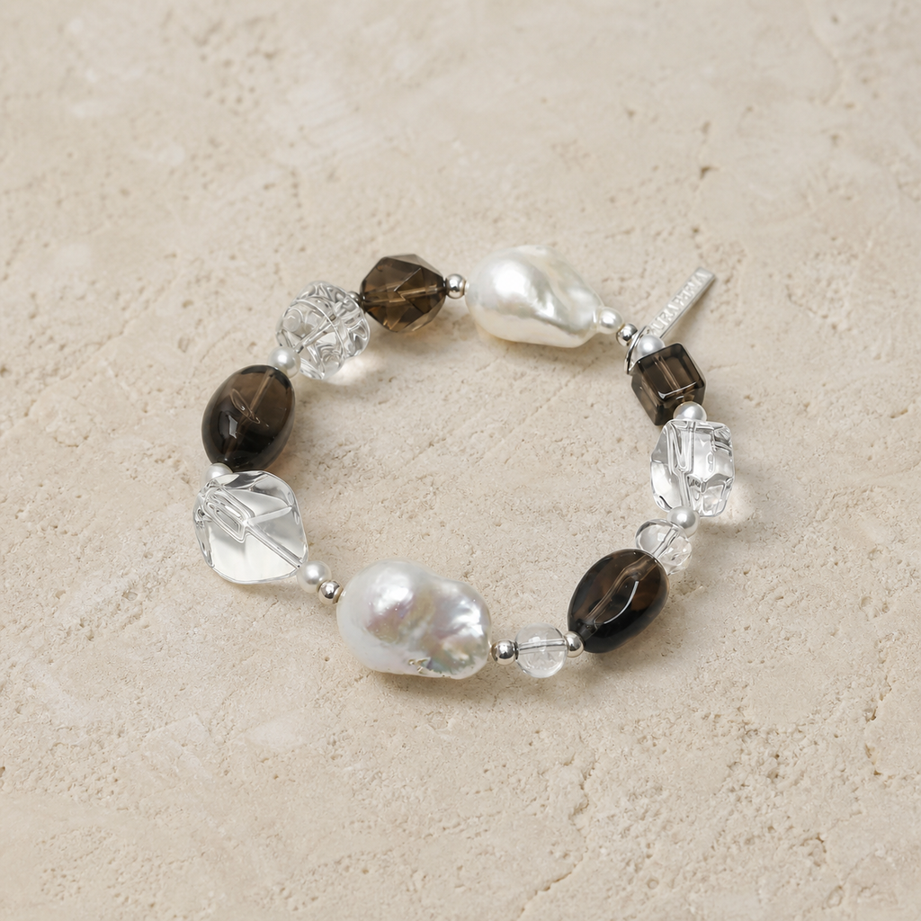Smoky quartz baroque pearl bracelet on a warm ivory studio background