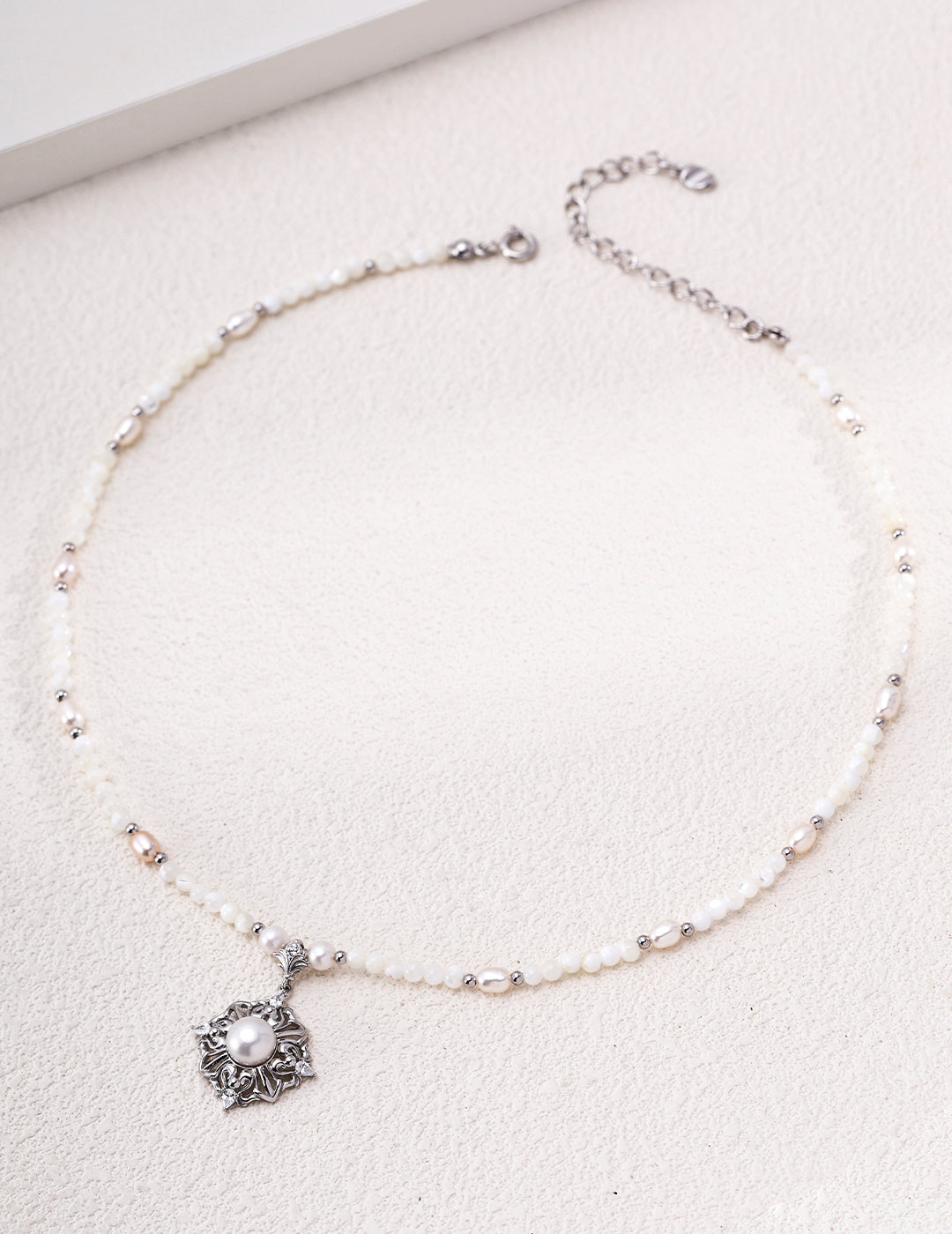 Silver-tone pearl necklace with a floral mother-of-pearl medallion