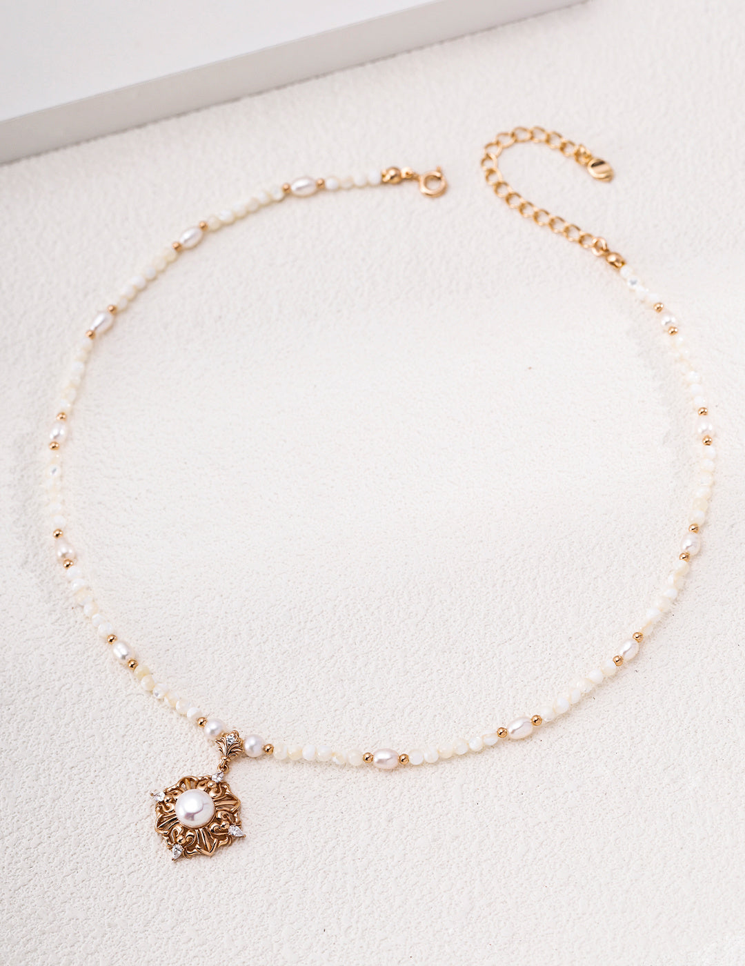 Vintage gold-tone pearl necklace with a floral mother-of-pearl medallion