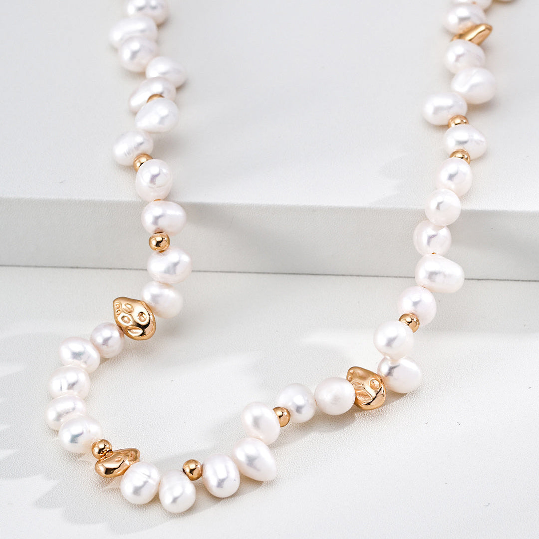 Close-up of irregular pearls and sculptural gold-tone beads